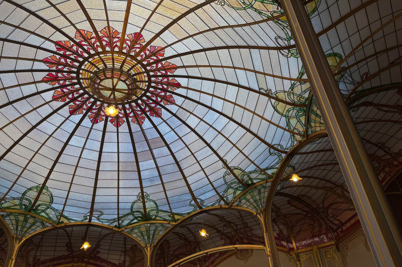Hôtel Van Eetvelde Art Nouveau stained-glass ceiling featuring organic lines and colorful glasswork.
